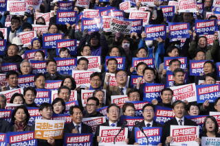 A crowd of people holding red signs