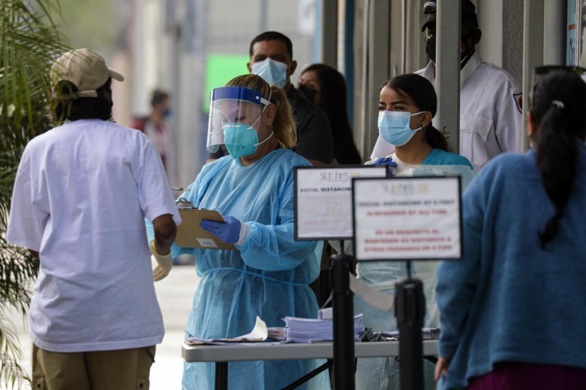 Healthcare workers screen patients Wednesday at St. John's Well Child and Family Center in Los Angeles.