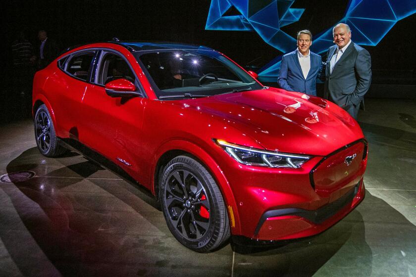 Ford CEO James Hackett (R) and a team member reveal the company's first mass-market electric car the Mustang Mach-E, which is an all-electric vehicle that bears the name of the companys iconic muscle car at a ceremony in Hawthorne, California on November 17, 2019. - This is Ford's first serious attempt at making a long-range EV and will be the flagship of a new lineup that will include an electric F-150 pickup truck. (Photo by Mark RALSTON / AFP) (Photo by MARK RALSTON/AFP via Getty Images) ** OUTS - ELSENT, FPG, CM - OUTS * NM, PH, VA if sourced by CT, LA or MoD **