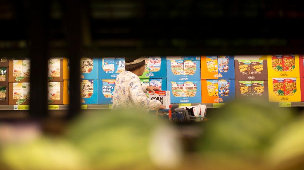 A shopper browses the cereal section at the Aldi food market in Inglewood. Cereal sales have gone flat because of concerns about nutrition and convenience.