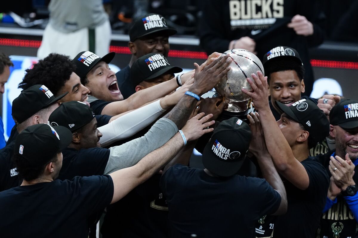 The Milwaukee Bucks hoist the trophy after defeating the Atlanta Hawks in Game 6 of the Eastern Conference finals in the NBA basketball playoffs and advancing to the NBA Championship, Saturday, July 3, 2021, in Atlanta. (AP Photo/John Bazemore)