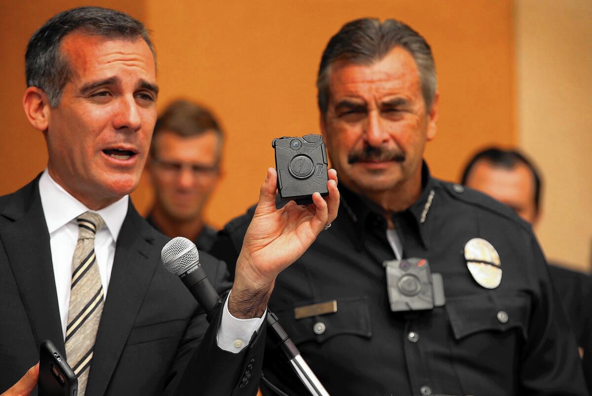 Los Angeles Mayor Eric Garcett holds a body camera and police Chief Charlie Beck models one at a news conference in September marking the rollout of the LAPD body carmera program.