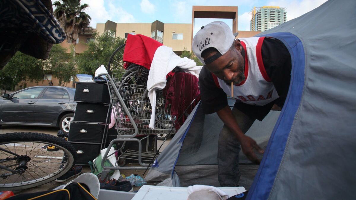 Randell, 50, a San Diego area homeless man, folds up his tent for the weekly cleanup on 17th Street downtown.