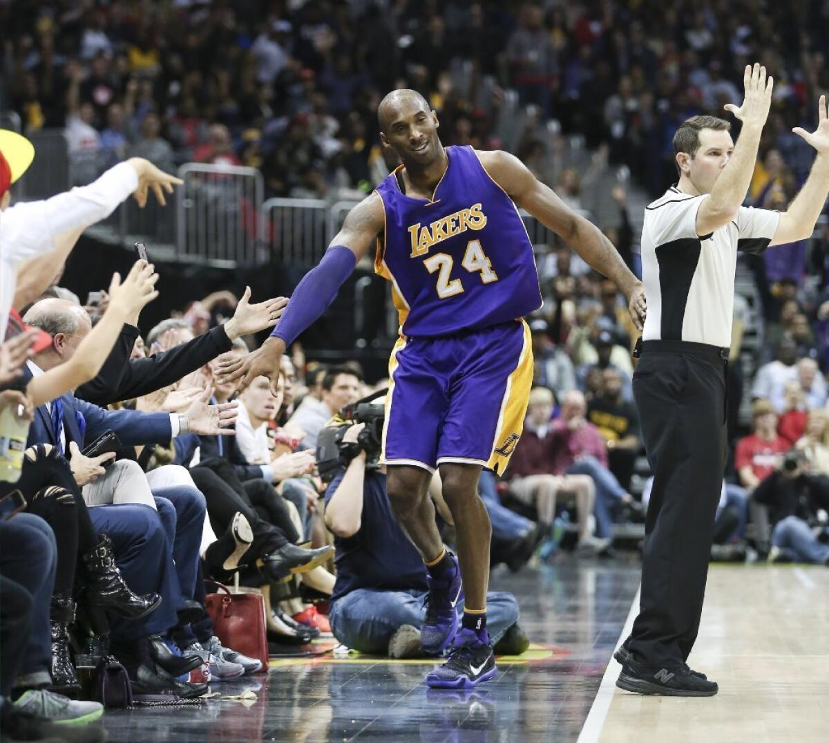 Kobe Bryant high-fives some fans during the Lakers' 100-87 loss to the Atlanta Hawks on Dec. 4.