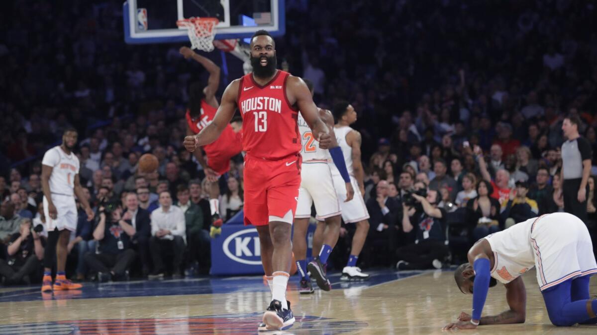 Houston Rockets' James Harden (13) reacts after teammate Kenneth Faried (35) dunked the ball during the second half of the team's game against the New York Knicks.
