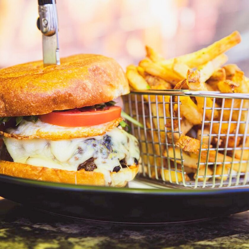 Burger nourri à l'herbe avec frites de parmesan à la truffe chez The French Gourmet.
