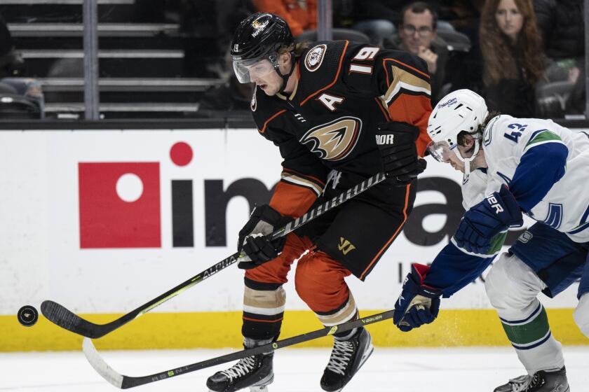 Anaheim Ducks right wing Troy Terry (19) and Vancouver Canucks defenseman Quinn Hughes.