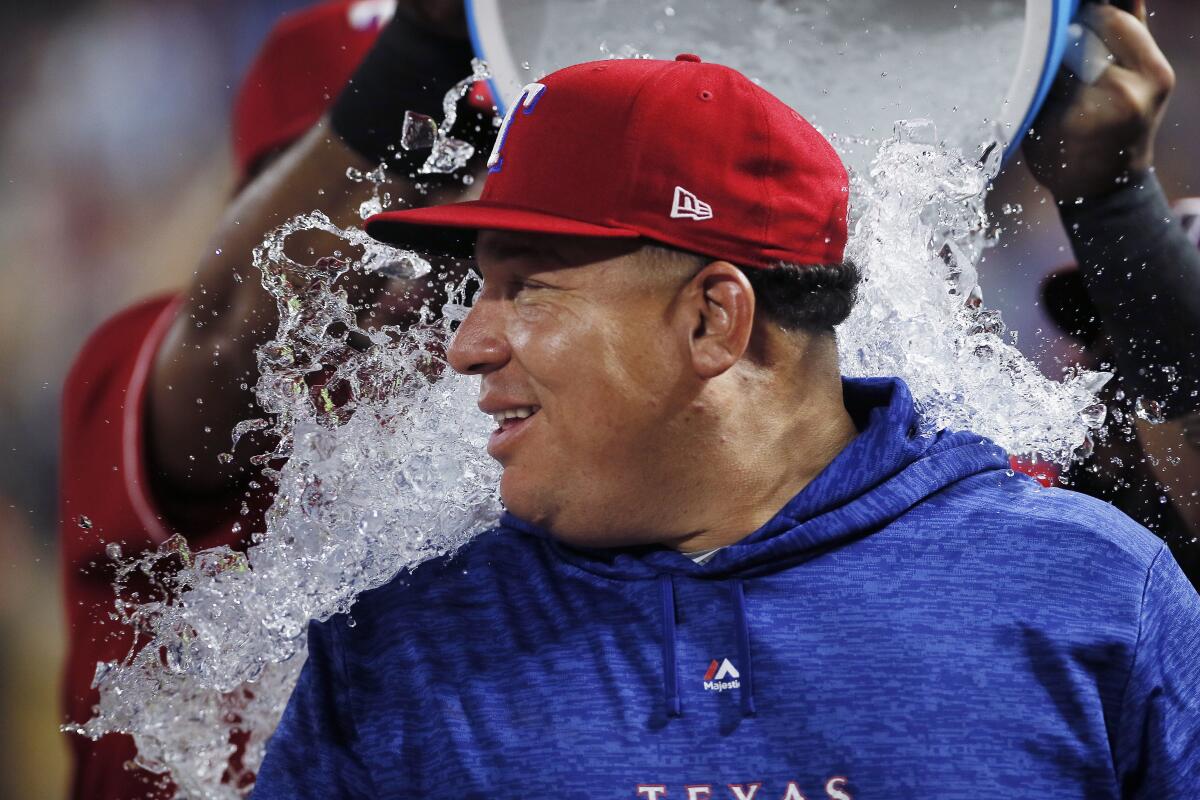 ARCHIVO - En esta foto de archivo del 7 de agosto de 2018, el dominicano Bartolo Colón, lanzador de los Rangers de Texas, es bañado con el contenido de la hielera tras obtener su triunfo número 246, la mayor cifra por parte de un latinoamericano en las mayores, ante los Marineros de Seattle (AP Foto/Brandon Wade, archivo)