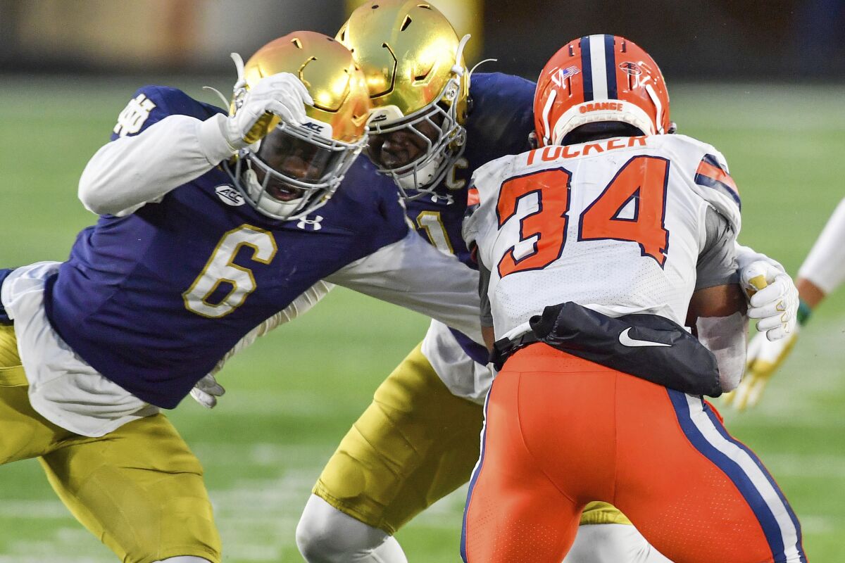 Syracuse running back Sean Tucker (34) is tackled by Notre Dame linebacker Jeremiah Owusu-Koramoah (6) during the third quarter of an NCAA college football game Saturday, Dec. 5, 2020, in South Bend, Ind. (Matt Cashore/Pool Photo via AP)