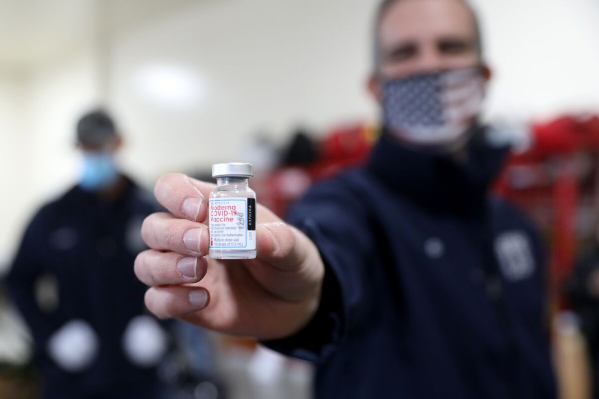L.A. Mayor Eric Garcetti holds a vial of the Moderna COVID-19 vaccine.