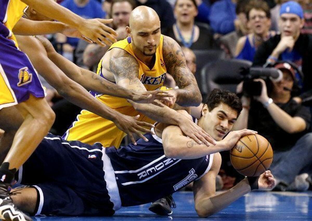 Thunder center Steven Adams tries to control a loose ball in a battle with Lakers center Robert Sacre in the first half.