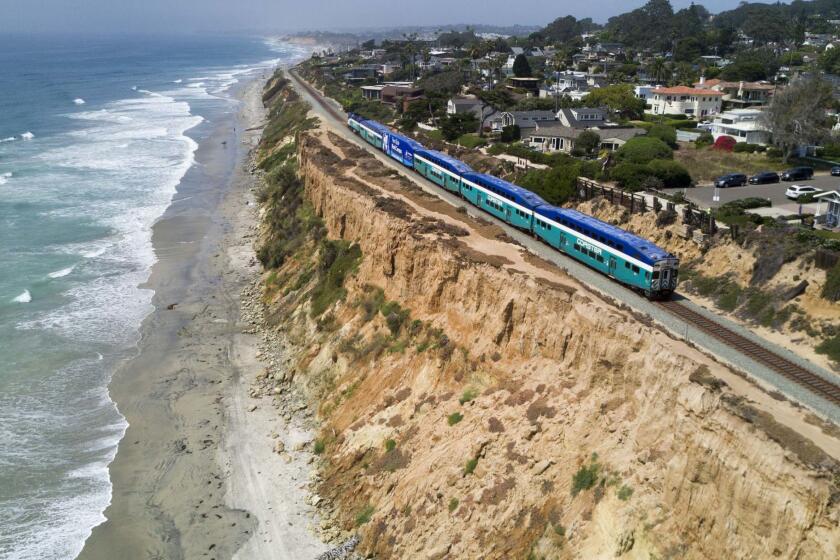 A Surfliner train by Amtrak travels along the collapsing bluffs in Del Mar.