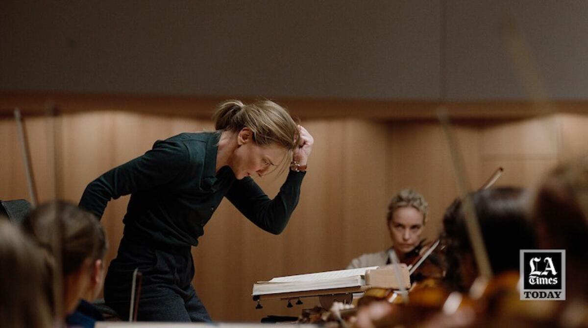 A woman conductor leads an orchestra in a scene from "Tár."