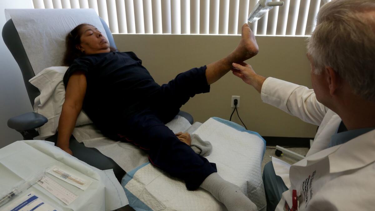 Dr. Stanley Mathis examines Maria Valdez at a White Memorial Medical Center clinic in Boyle Heights that treats wounds caused by diabetes. Valdez had surgery to save her foot. A new report says diabetes care eats up close to 5% of all U.S. health spending.
