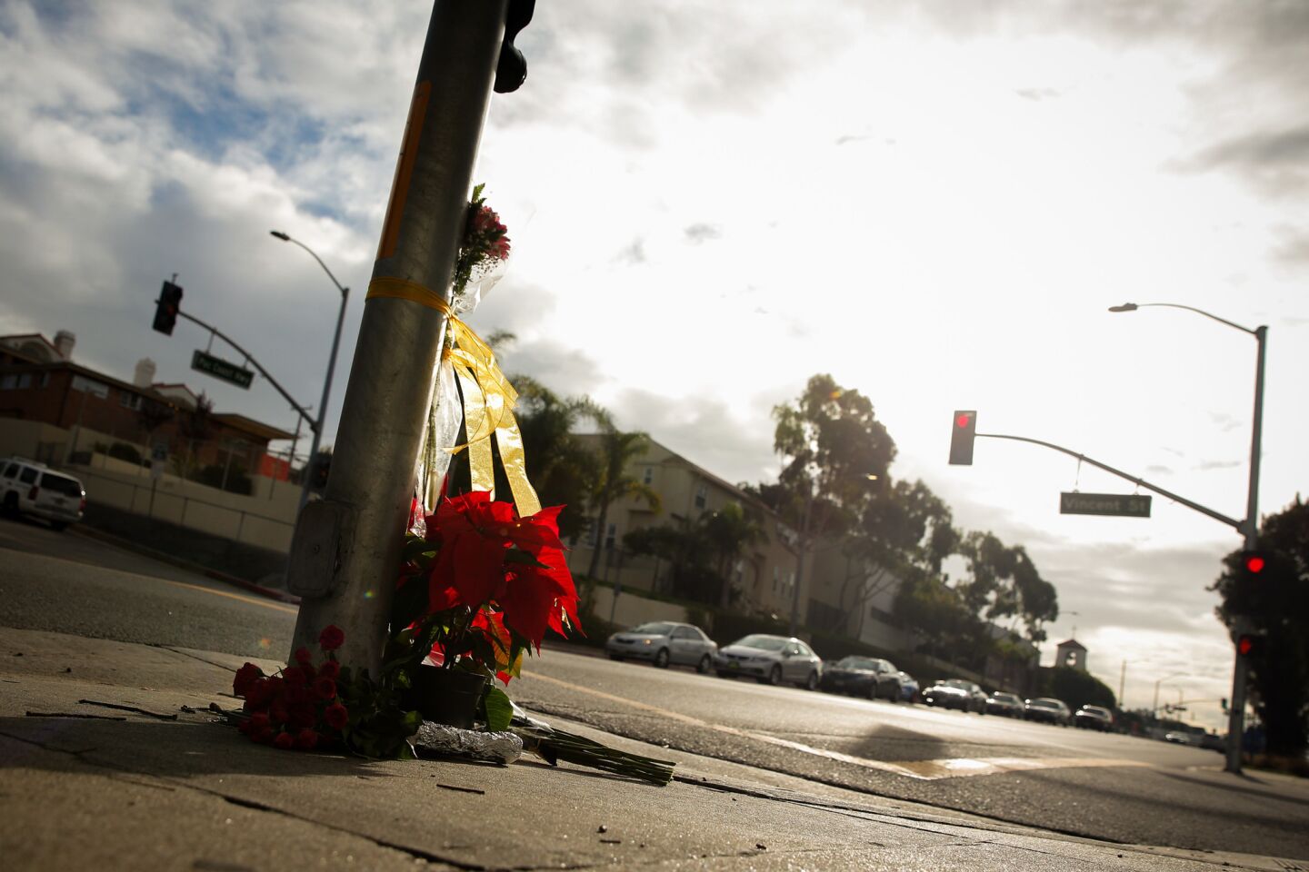 Flowers accumulate at the corner of Vincent Street and Pacific Coast Highway in Redondo Beach on Thursday, the morning after three women were killed when a car plowed into a group of people in a crosswalk in front of St. James Catholic Church.