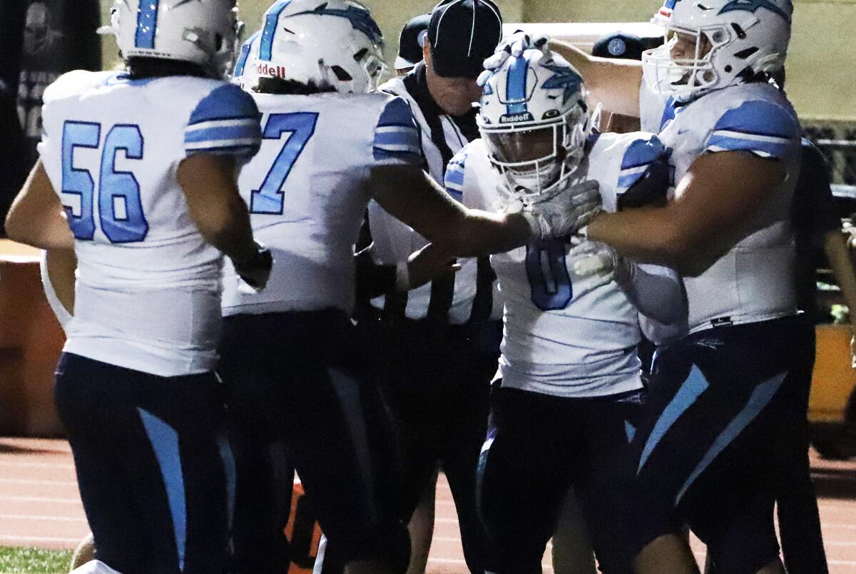Corona del Mar's Dorsett Stecker (0) scores a touchdown and is congratulated by his teammates against Edison on Friday.