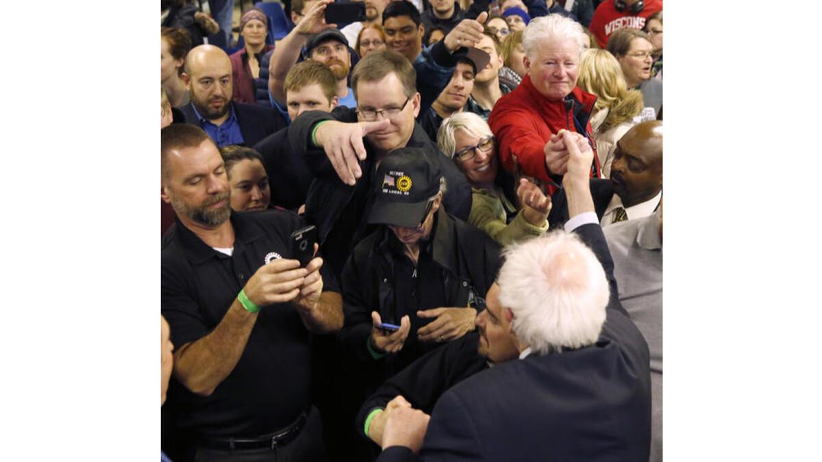 Democratic presidential candidate Sen. Bernie Sanders is mobbed by supporters at a rally at a union hall in Janesville, Wis., on April 4, 2016.