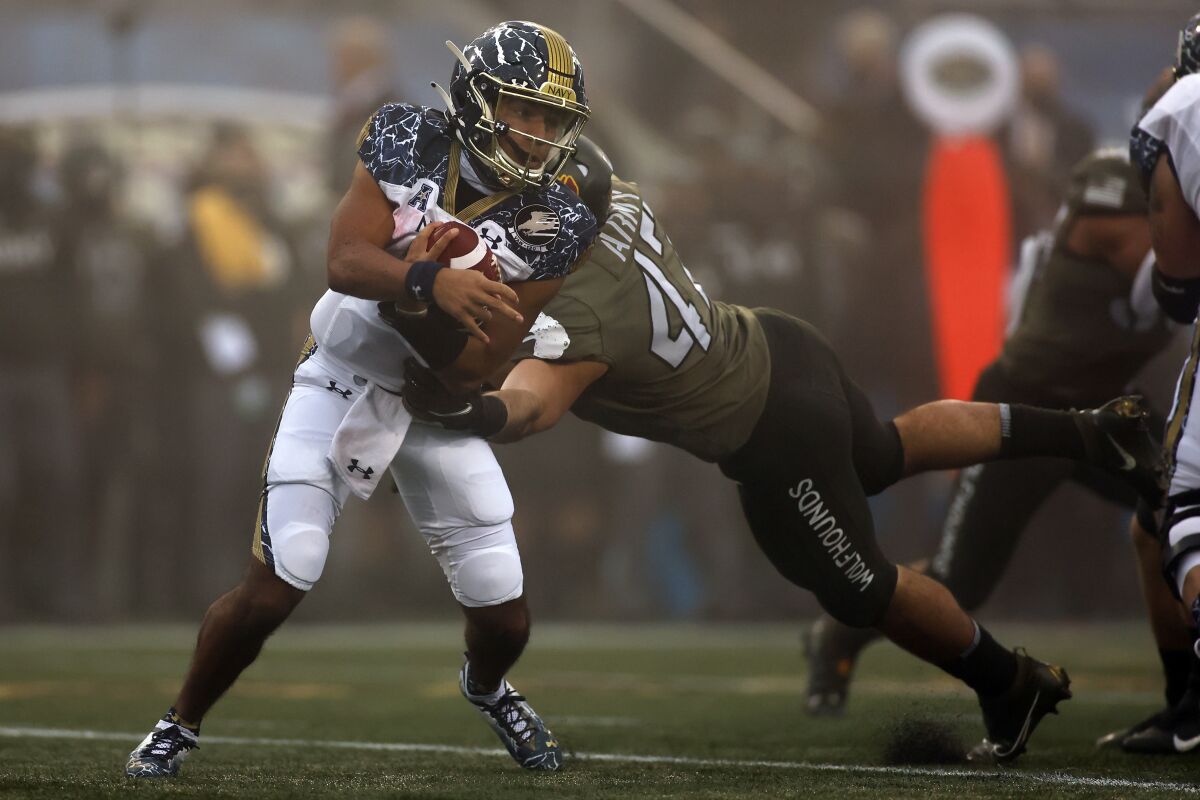 FILE - Navy quarterback Xavier Arline (7) is tackled by Army linebacker Jon Rhattigan (47) during the first half of an NCAA college football game Saturday, Dec. 12, 2020, in West Point, N.Y. Bowl-bound Army looks to beat Navy for 5th time in 6 games as both teams meet on Saturday, Dec. 11, 2021. (AP Photo/Adam Hunger)