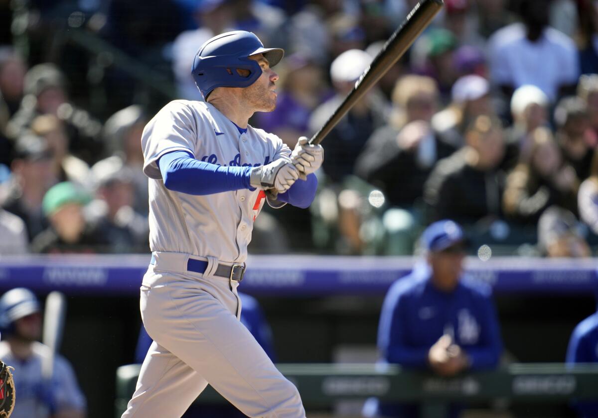  The Dodgers' Freddie Freeman follows the flight of his fly ball dropped by Rockies left fielder Kris Bryant on Sunday.