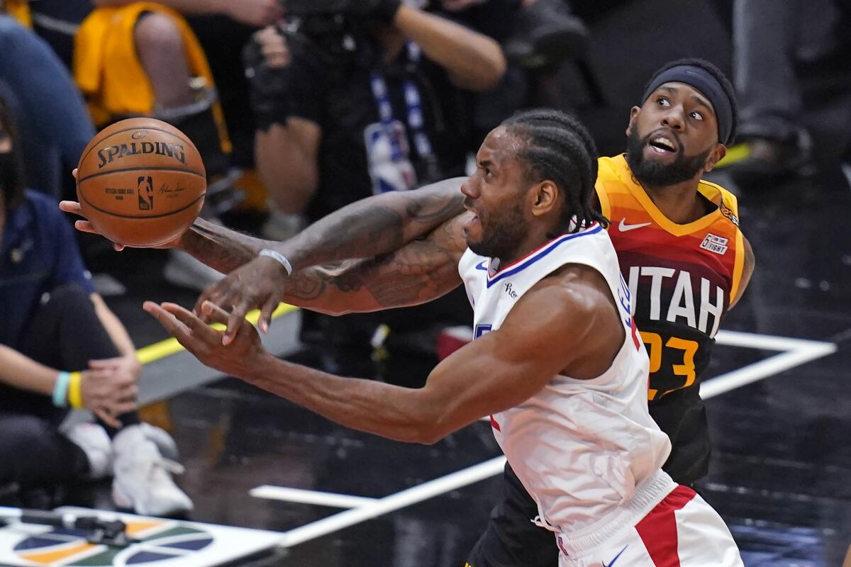 Clippers forward Kawhi Leonard is fouled by Jazz forward Royce O'Neale on a drive to the basket.