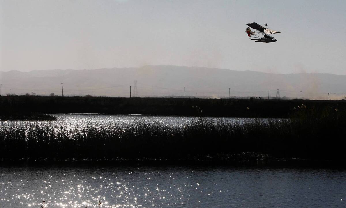 An ultralight aircraft flies over reeds and tule near Bacon Island in the Sacramento-San Joaquin River Delta. Federal agencies reviewing draft environmental documents for the state’s proposal to re-plumb the delta are criticizing the work as “insufficient,” “biased” and “confusing.”