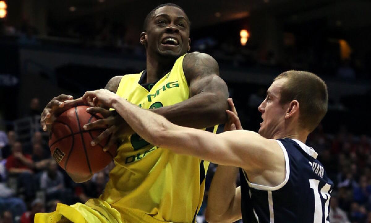 Oregon's Elgin Cook, left, is fouled by BYU's Josh Sharp while driving to the basket during the Ducks' NCAA tournament victory Thursday.