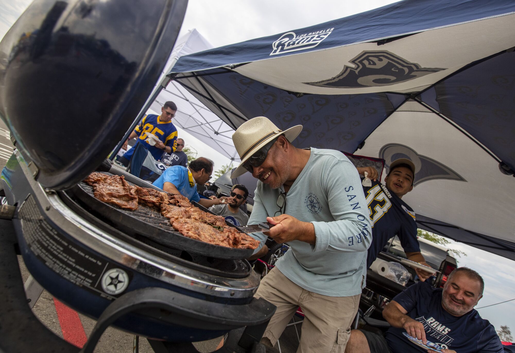 Hector Romero of San Diego grills up carne asada while tailgating Saturday at SoFi Stadium.