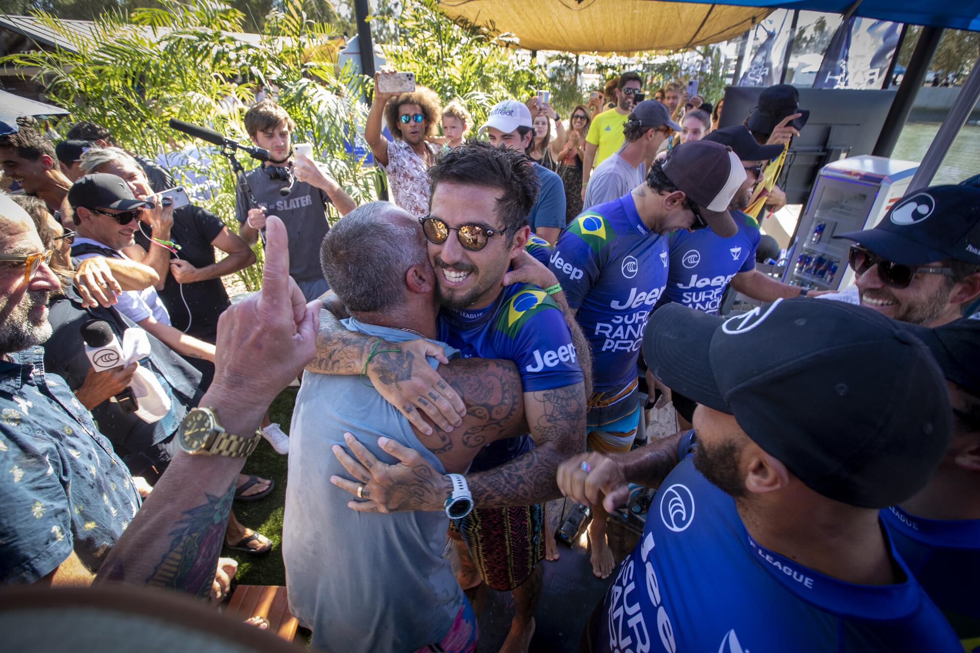 Ricardo Toledo hugs his son, Filipe Toledo of Brazil, on a special father's day while fellow countrymen.