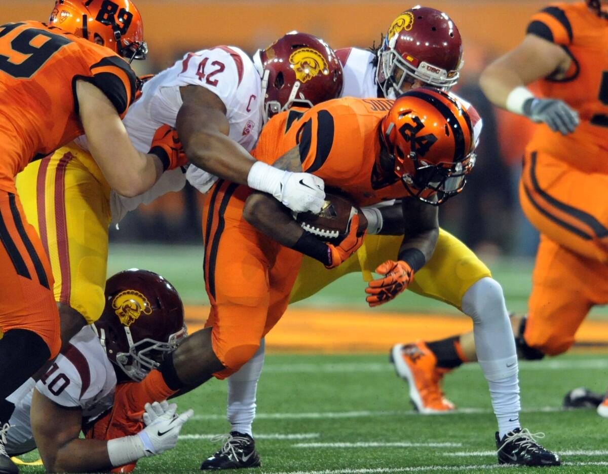 USC linebacker Devon Kennard (42) helps bring down Oregon State running back Storm Woods in the first half.