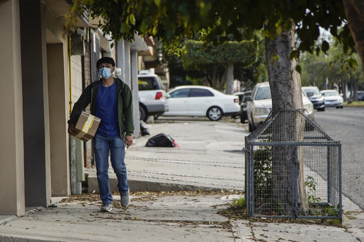 Un hombre camina con un paquete de Mercado Libre en Tijuana.