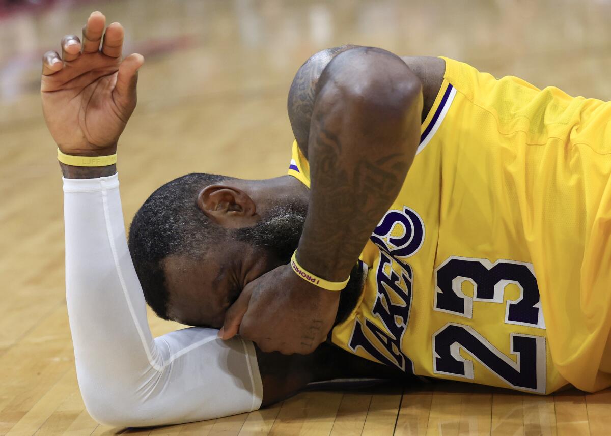 LeBron James lies on the court with a hand over his face.