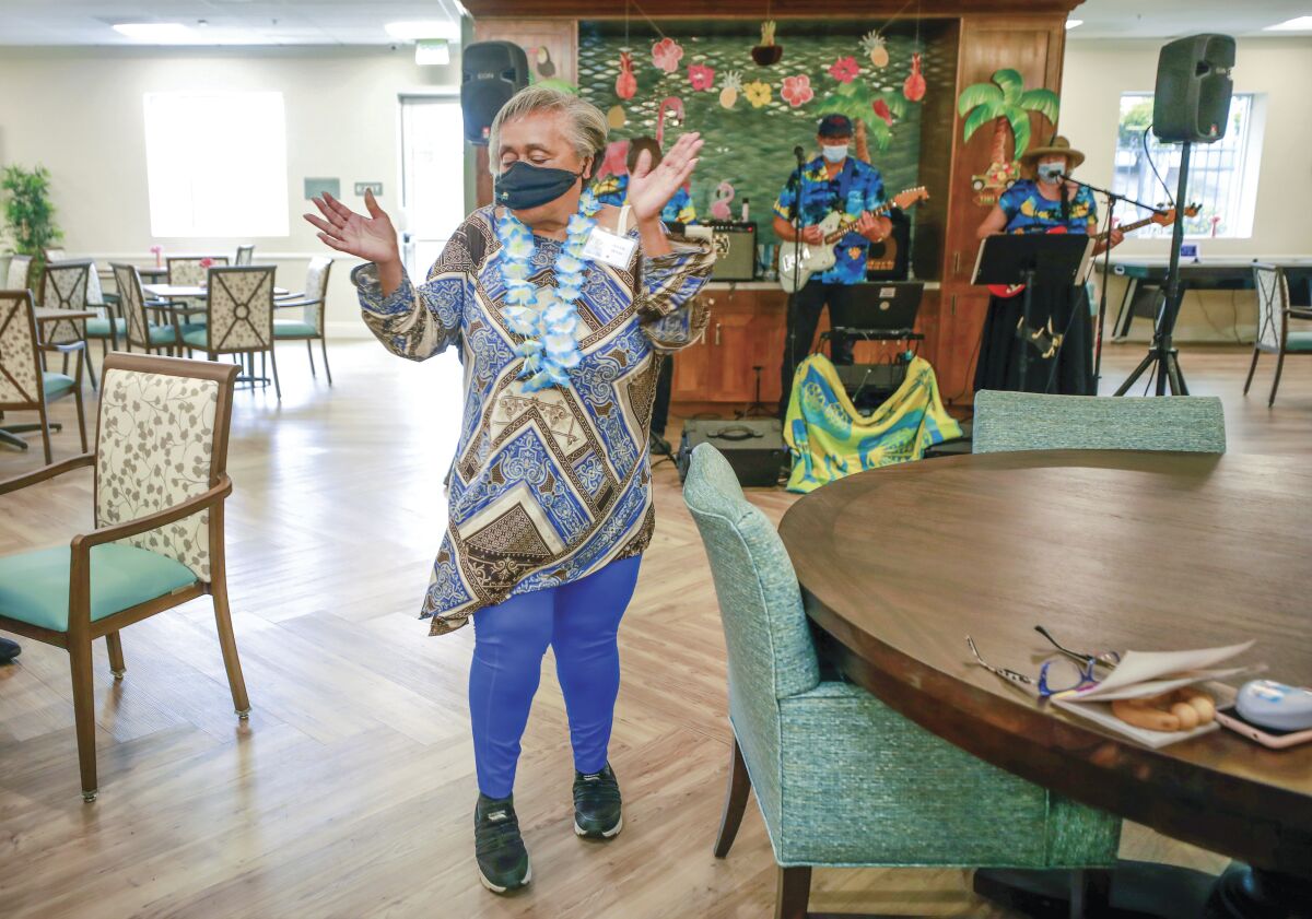 A 74-year-old woman dances to a band playing at a center that provides services and programs for seniors.