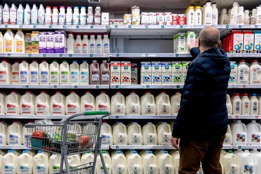 A shopper walks through the dairy aisle of a grocery store in Washington, DC, on February 19, 2022. (Photo by Stefani Reynolds / AFP) (Photo by STEFANI REYNOLDS/AFP via Getty Images)