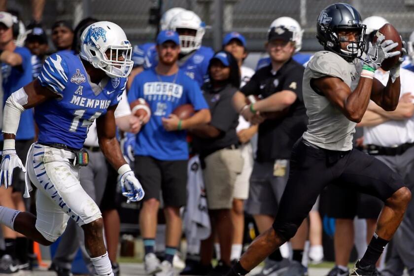 Central Florida wide receiver Tre'Quan Smith, right, catches a pass in front of Memphis defensive back Jonathan Cook for a 50-yard touchdown during the first half of the American Athletic Conference championship NCAA college football game, Saturday, Dec. 2, 2017, in Orlando, Fla. (AP Photo/John Raoux)