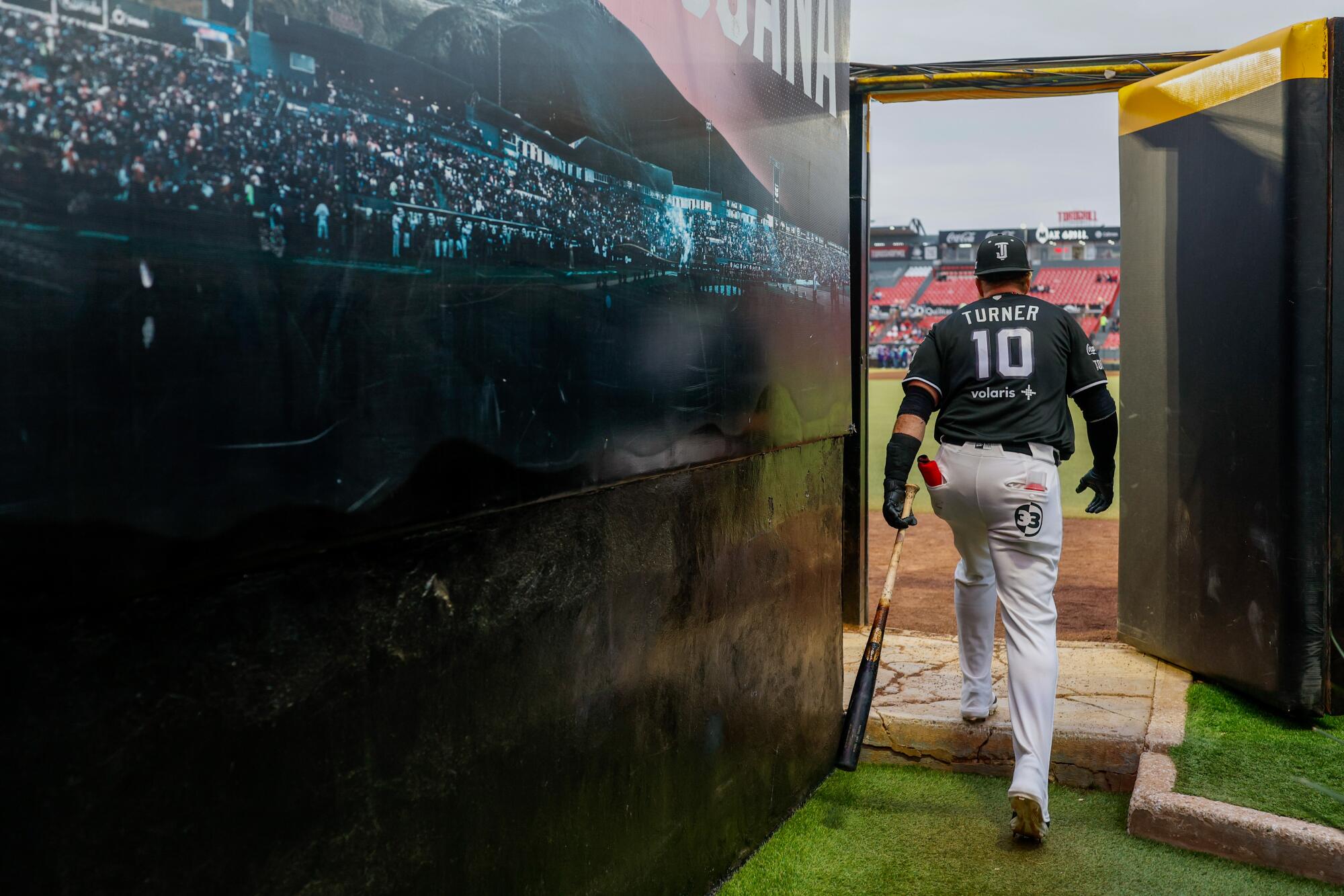 Justin Turner, Cuma günkü Tijuana Toros maçı öncesinde ısınma çalışmalarını tamamlamak için dövüş kafeslerinden çıkıp sahaya çıkıyor.