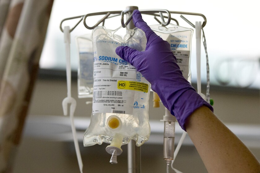 A nurse places a patient's chemotherapy medication on an intravenous stand at a hospital in Philadelphia. A report released on Jan. 7, 2016, says cancer was the leading cause of death in 22 states in 2014.