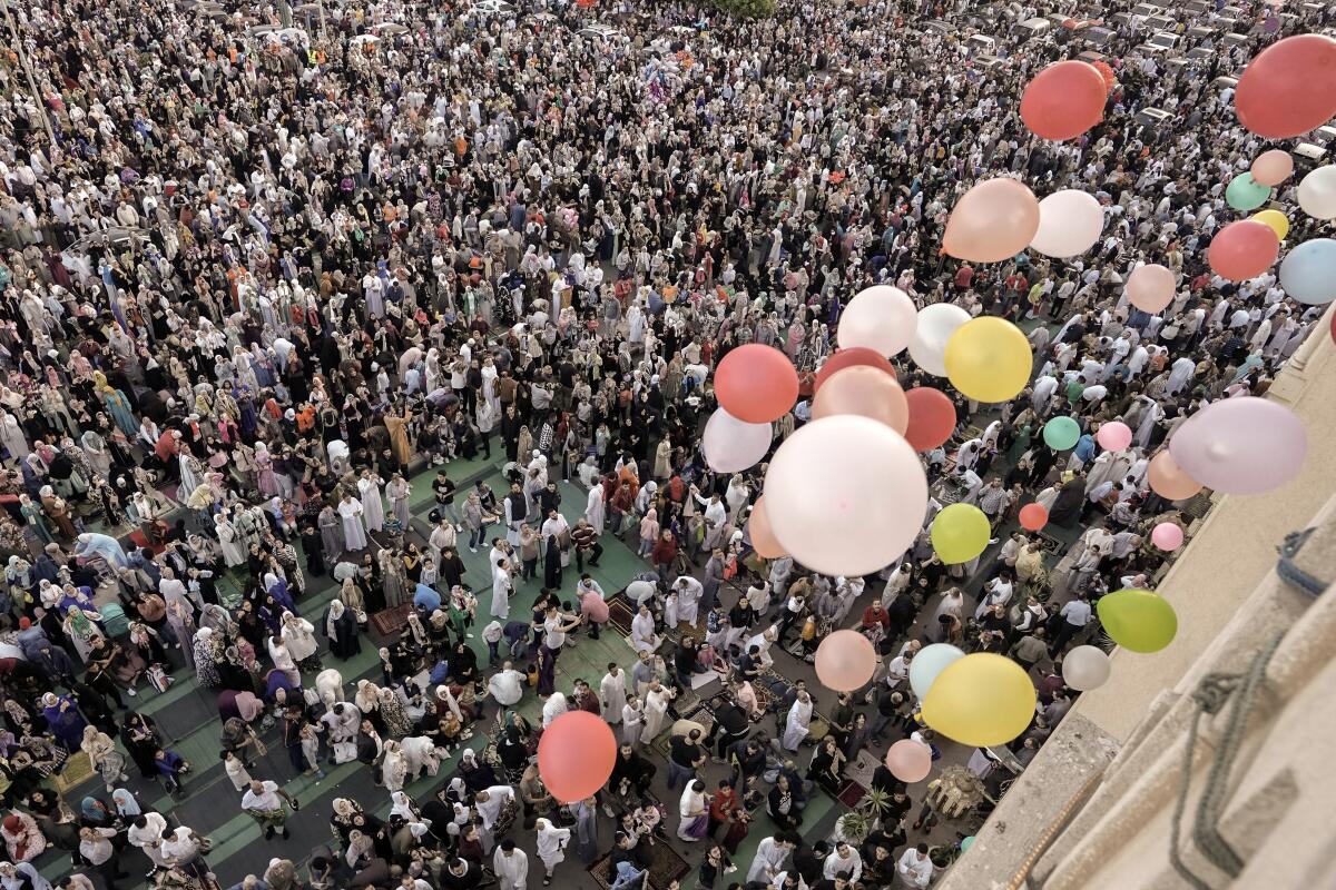Distribuyen globos tras el fin de las oraciones de Eid al-Fitr, el día que marca el final del mes santo de ayuno del Ramadán,