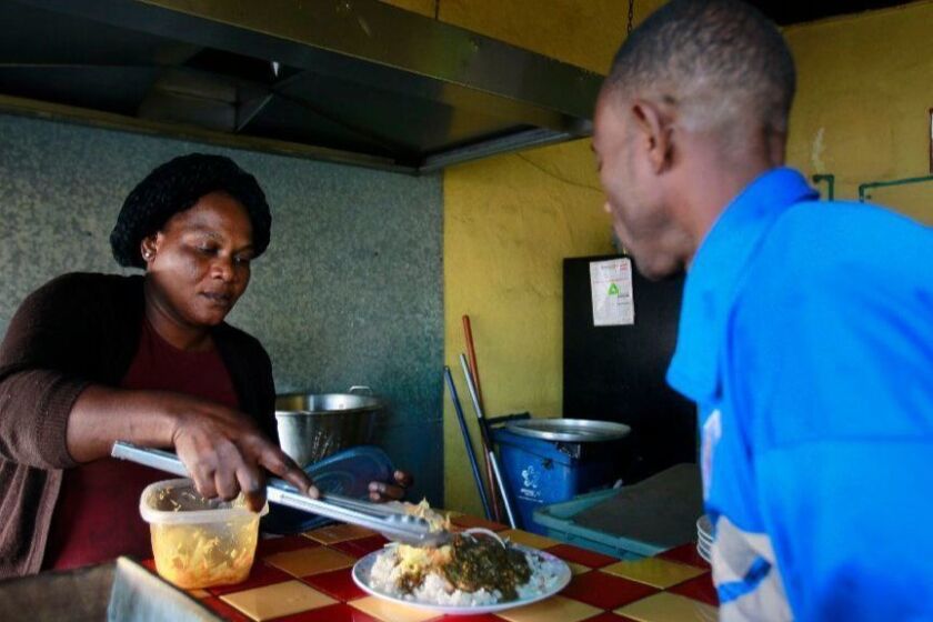 TIJUANA, November 28, 2018 | Theresa Moise, who is from Haiti, serves Kesmer Mollisoint, also from Haiti, a plate of Haitian food at the Labadee restaurant where Moise works as a cook in Tijuana, Mexico on Wednesday. | Photo by Hayne Palmour IV/San Diego Union-Tribune/Mandatory Credit: HAYNE PALMOUR IV/SAN DIEGO UNION-TRIBUNE/ZUMA PRESS San Diego Union-Tribune Photo by Hayne Palmour IV copyright 2018
