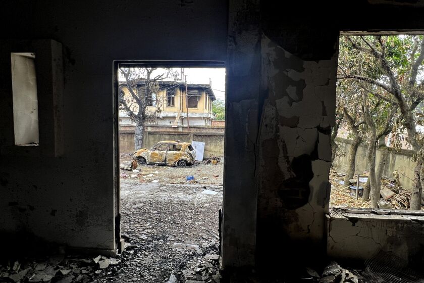 A burnt car stands in the compound of a vandalised home in Imphal, capital of the northeastern Indian state of Manipur, May 14, 2023. The state, which borders Myanmar, has been roiled by violence for weeks after members of mostly Christian tribal groups clashed with the Hindu majority over its demands for special economic benefits. (AP Photo/Yirmiyan Arthur)