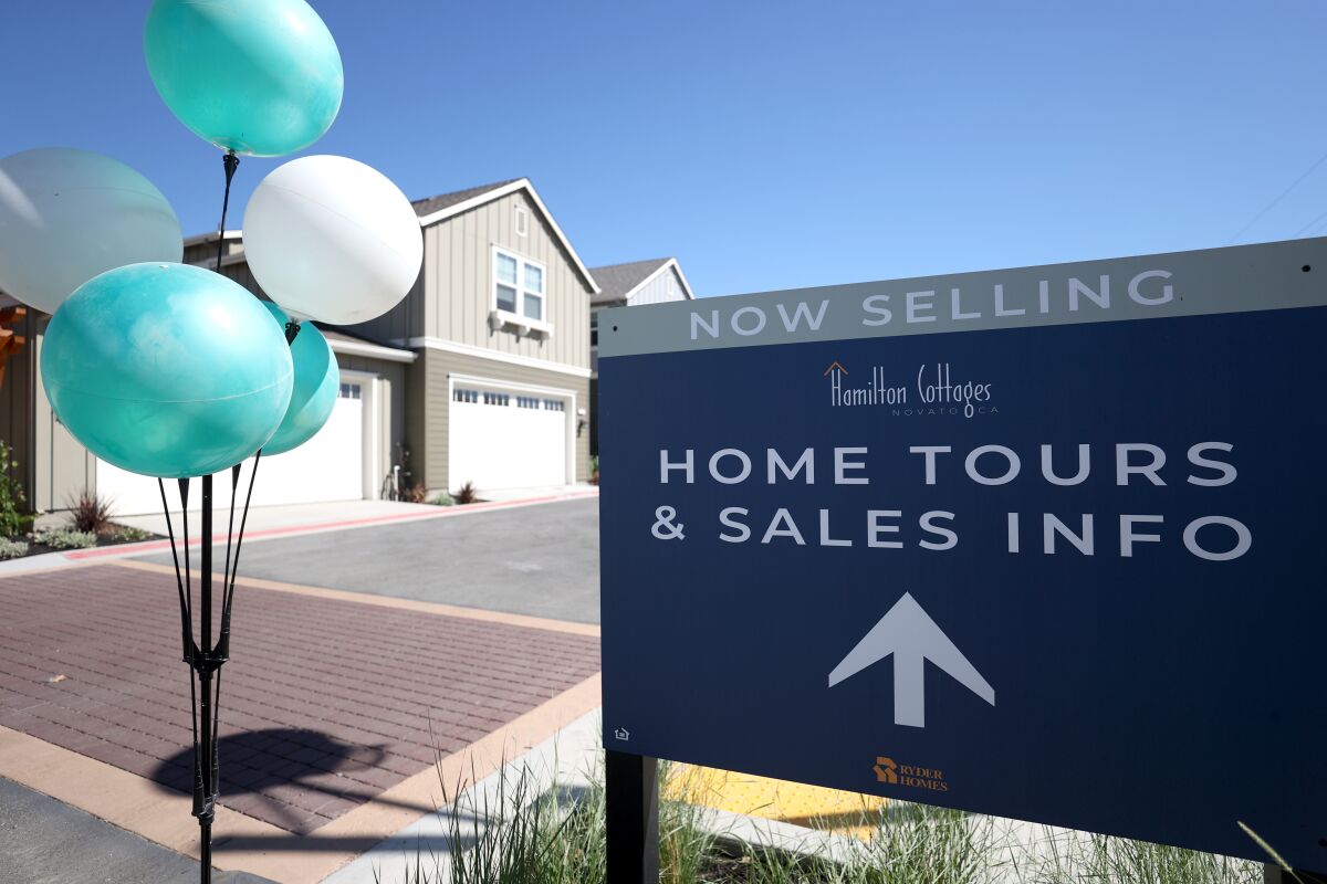 A sign is posted in front of new homes for sale at Hamilton Cottages last September in Novato, Calif.