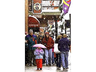 Early-season shoppers throng the sidewalks of Main Street