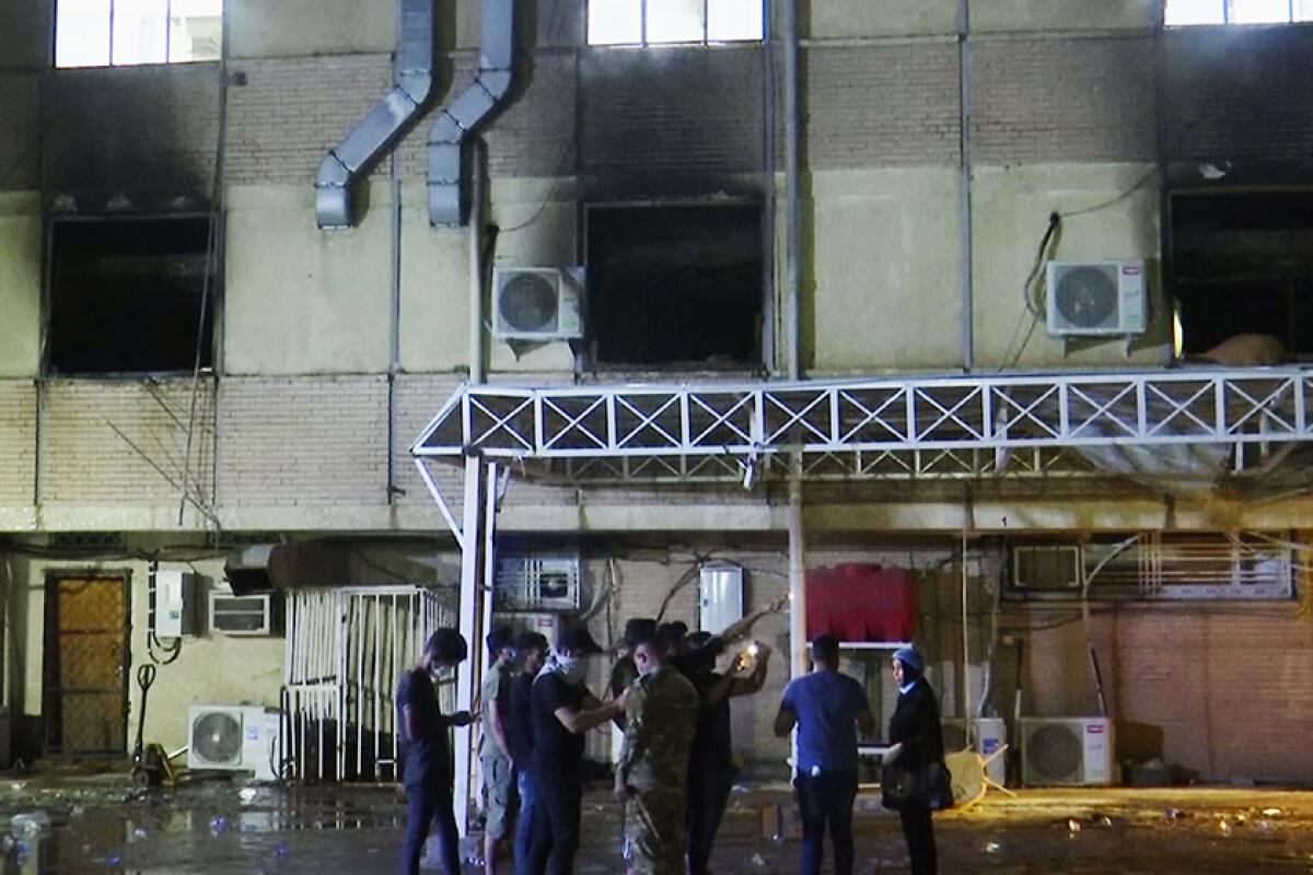 Smoke-blackened windows are seen in a hospital building.