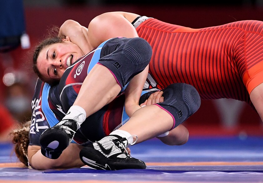 Adeline Gray grimaces as an opponent grasps her around the neck on the mat.
