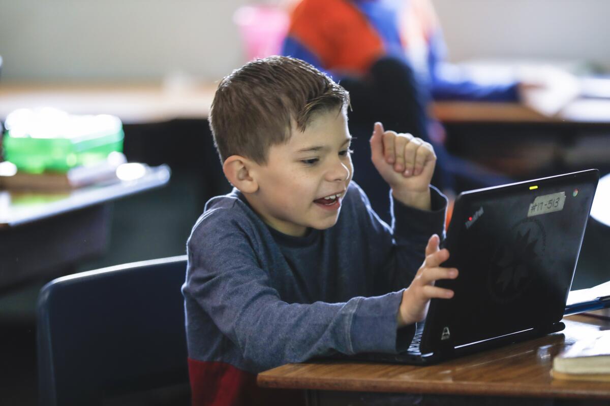 Fifth grader Johnny Moore, 10 from Perkins Elementary School, uses a laptop in February.