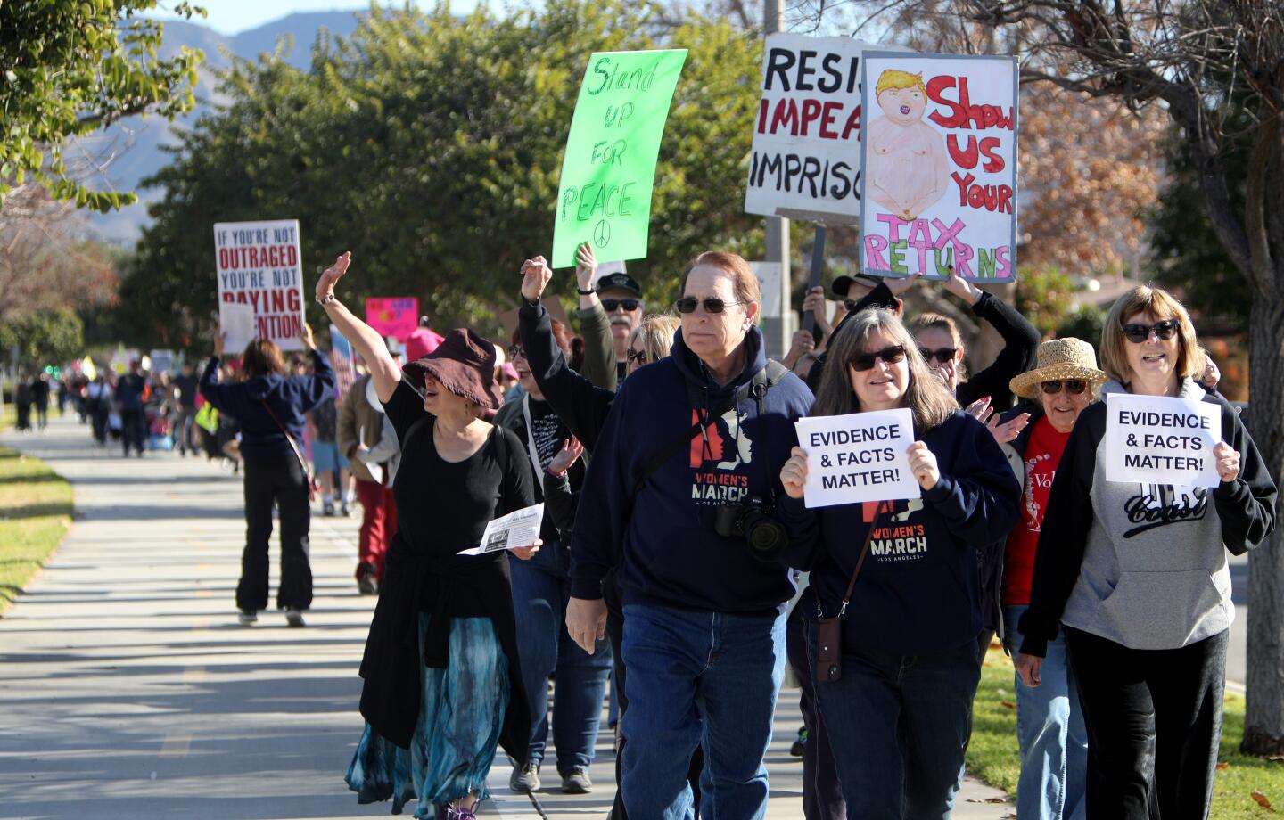 Hundreds like, from left, Larry and Susan Rosenberg and Pam Springs marched with signs during the Women's March on the Chandler Bikeway in Burbank on Saturday, Jan. 18, 2020.