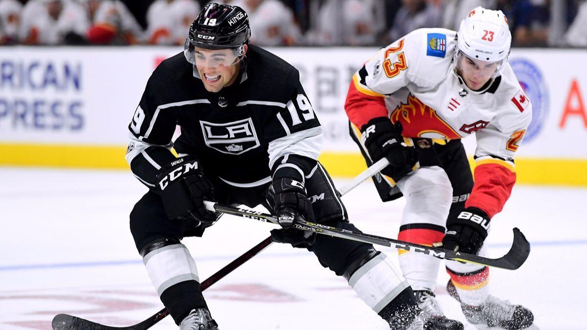 The Kings' Alex Iafallo keeps the puck away from the Calgary Flames' Sean Monahan during an Oct. 11 game.