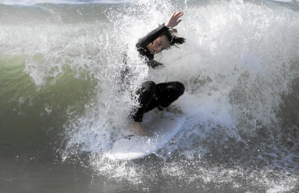 Surfers in Huntington Beach and at other spots along the Southern California coast are taking advantage of big waves generated by "king tides."