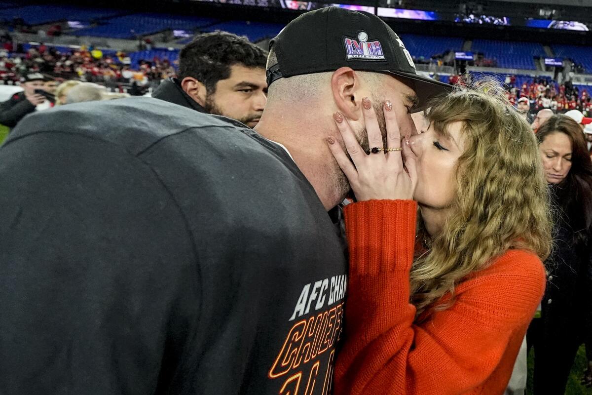 Taylor Swift kisses Chiefs tight end Travis Kelce after the AFC championship game.
