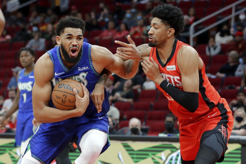 Minnesota Timberwolves center Karl-Anthony Towns, left, drives around Houston Rockets center Christian Wood, right, during the first half of an NBA basketball game Sunday, Jan. 9, 2022, in Houston. (AP Photo/Michael Wyke)