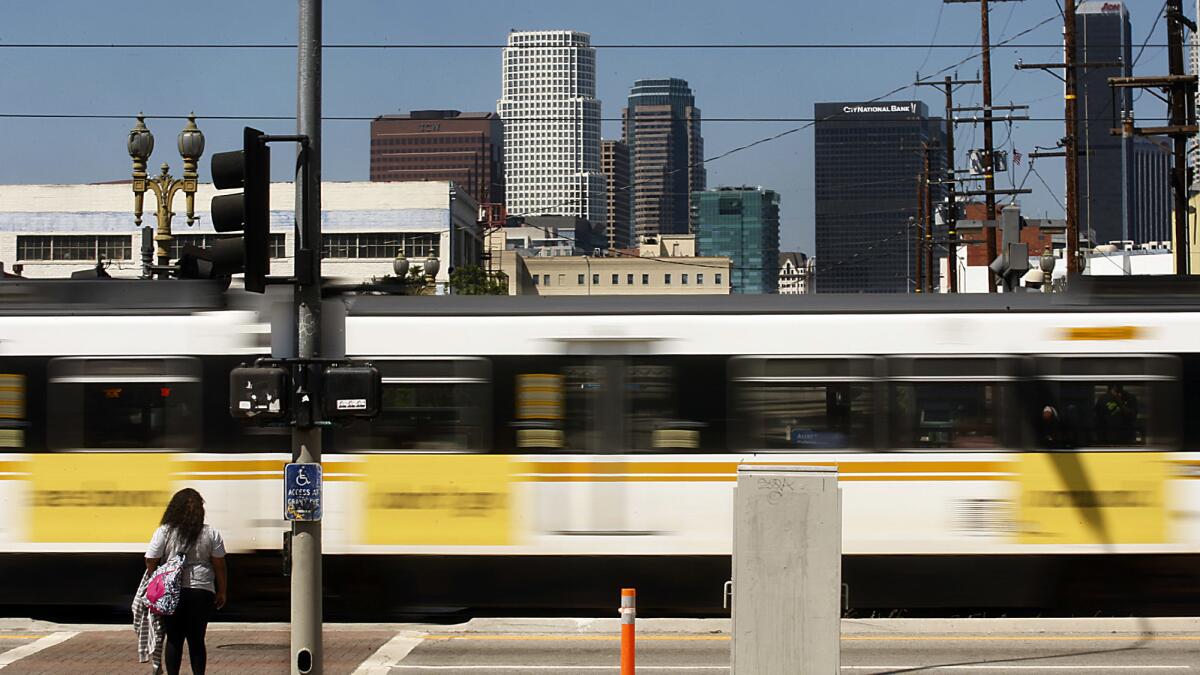 Metro Blue Line cars zip past a station near Washington Boulevard and Flower Street.